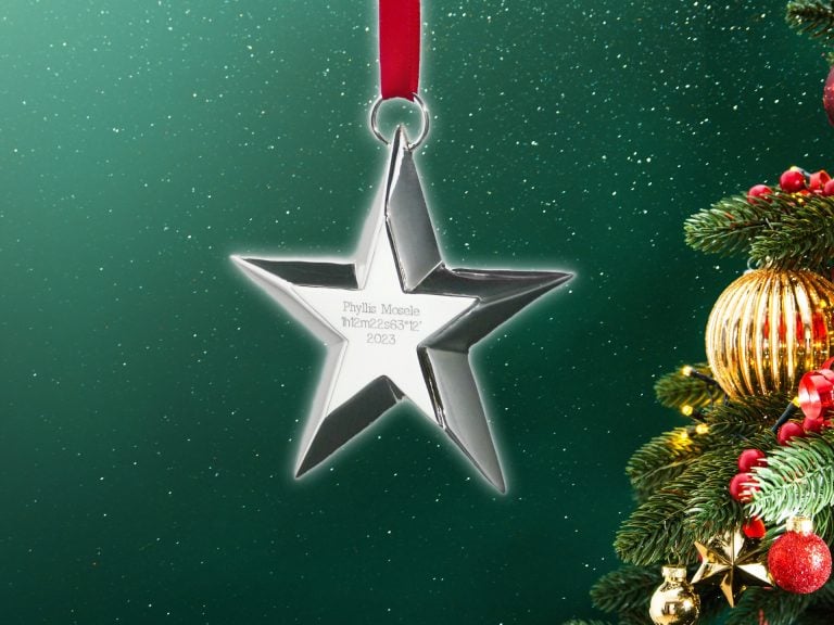 Star shaped ornament suspended by a red ribbon