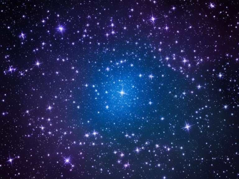 blue and purple star field filled with bright stars. The larger stars have beams of light.