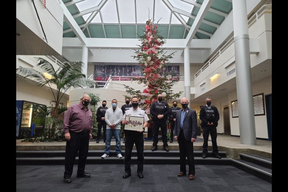 Image of police holding an International Star Registry certificate in front of a Christmas tree.